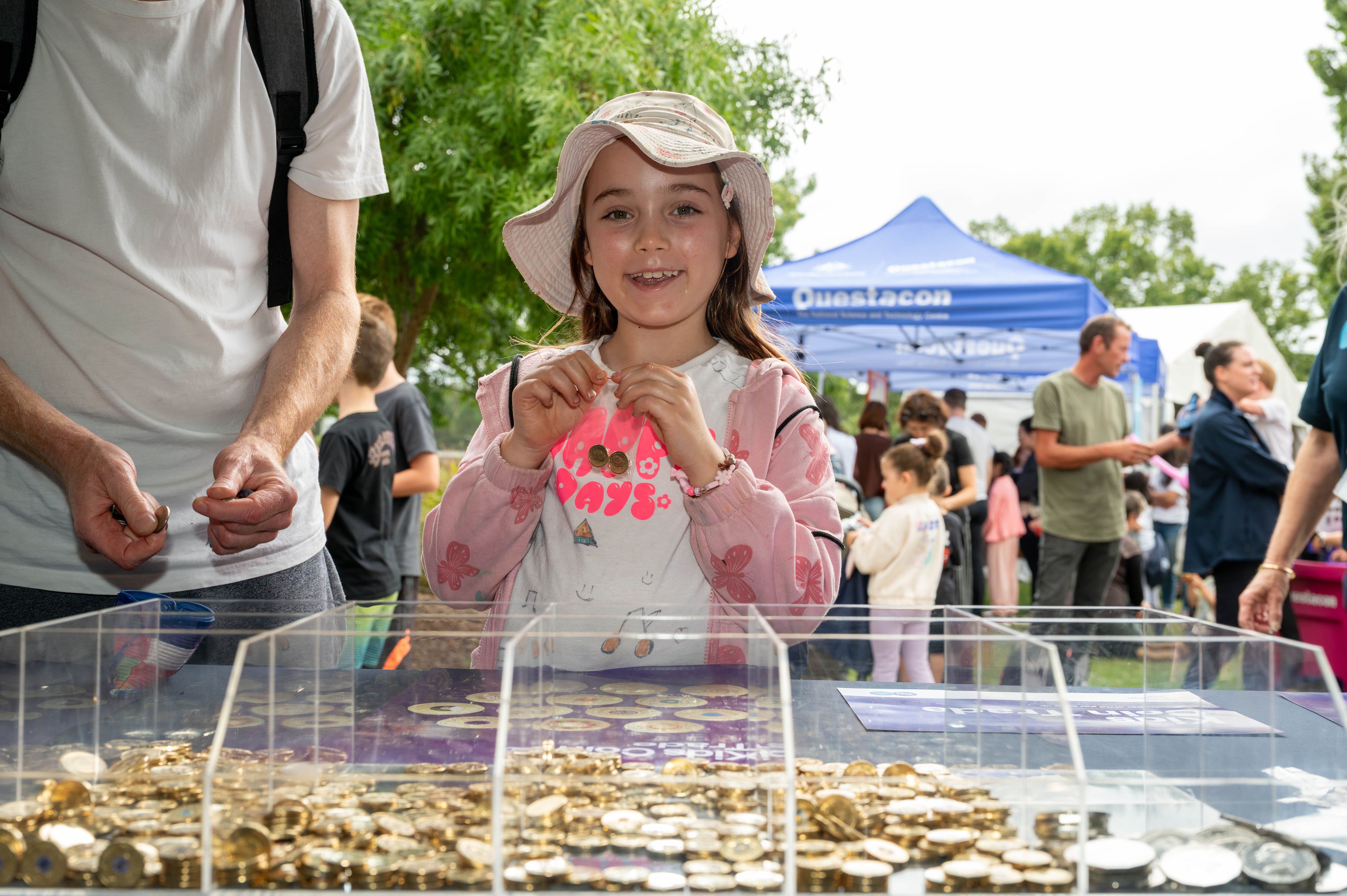 Child holding a coin at the Kids Coin Trade