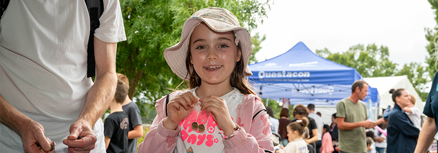 Child holding a coin at the Kids Coin Trade