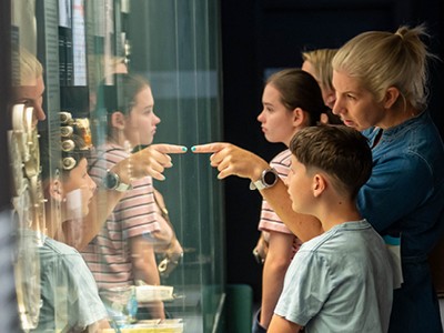 A family looks into a glass coin display at the Royal Australian Mint.