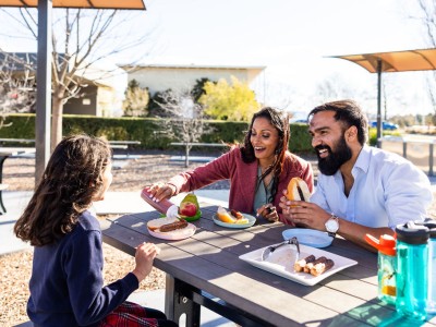 Family enjoying a meal using the outdoor BBQ at the Mint.